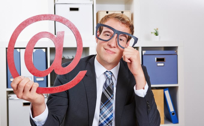 A man in a suit holding up an email marketing sign.
