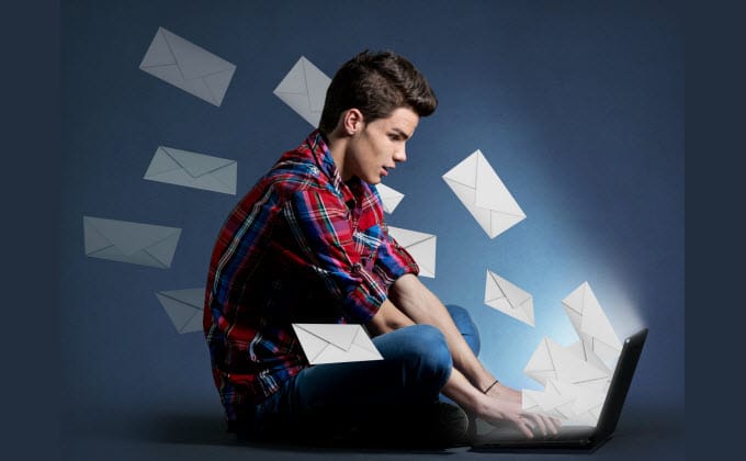 The man is sitting on a laptop, surrounded by a flurry of emails, contemplating the optimal frequency for emailing his list.
