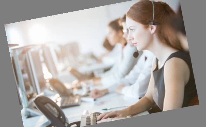 A group of people service on social media from her computer in a call center.