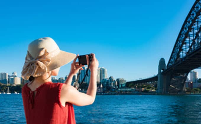 A woman take a picture Sydney Harbour Bridge.