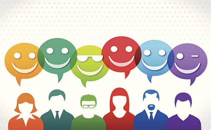 A group of smiling people promoting emoji marketing with speech bubbles.