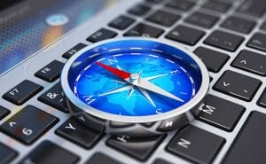 A laptop keyboard is accompanied by a compass.