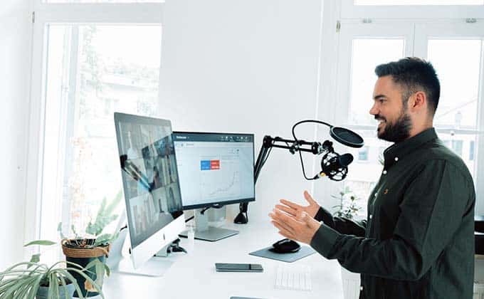 A man standing in front of a desk with a microphone,