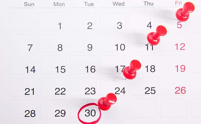 A calendar with four red pins