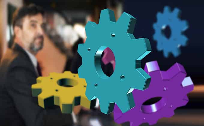 A man in a suit is standing in front of a group of colorful gears, illustrating an automated marketing process.