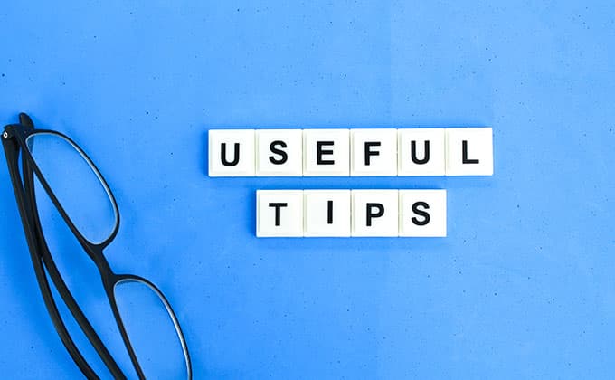 Eyeglasses next to white letter tiles spelling “USEFUL TIPS”